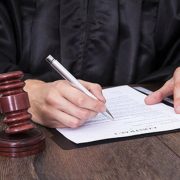 judge writing a note beside a gavel