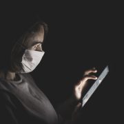 Person holding a smartphone while wearing a COVID-19 mask